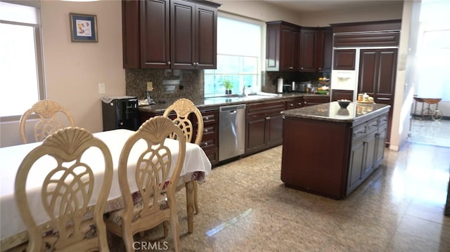 kitchen featuring dark brown cabinetry, decorative backsplash, dishwasher, and a kitchen island