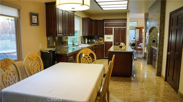 kitchen with tasteful backsplash, pendant lighting, a wealth of natural light, and a center island