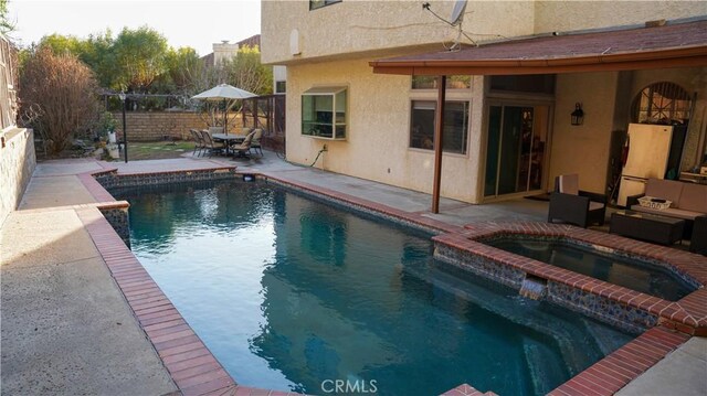 view of pool with an in ground hot tub, an outdoor hangout area, and a patio