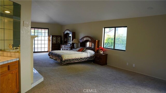 carpeted bedroom with multiple windows and vaulted ceiling