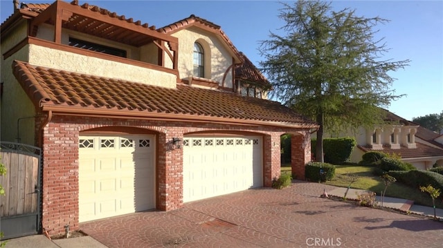 mediterranean / spanish home featuring a garage and a balcony