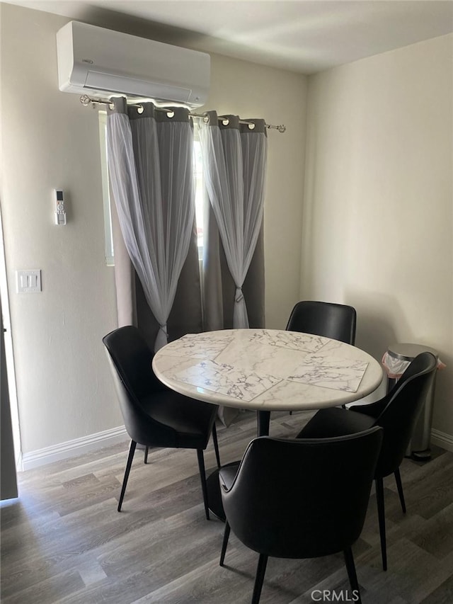 dining space featuring a wall mounted air conditioner and hardwood / wood-style floors