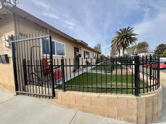 view of gate with a yard