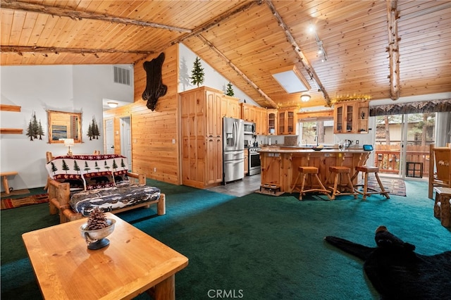 carpeted living room featuring rail lighting, a skylight, high vaulted ceiling, wooden ceiling, and beamed ceiling