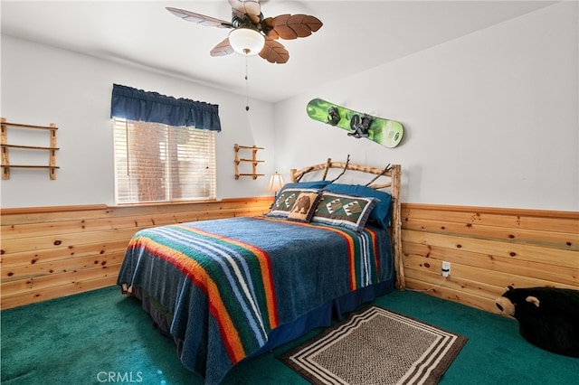 bedroom featuring dark carpet, ceiling fan, and wood walls