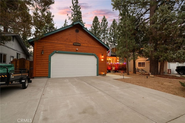 log-style house featuring a garage and an outdoor structure