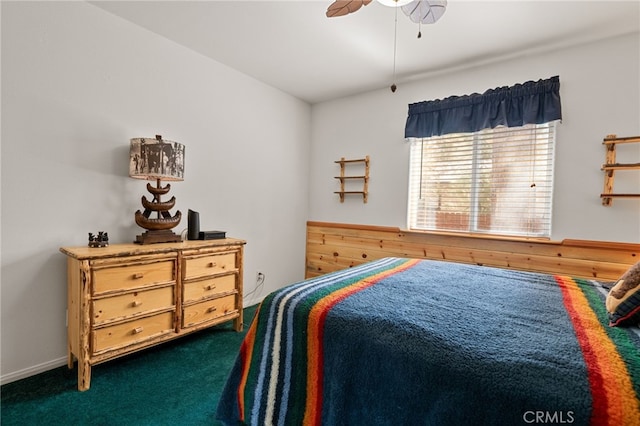 carpeted bedroom with ceiling fan and wood walls