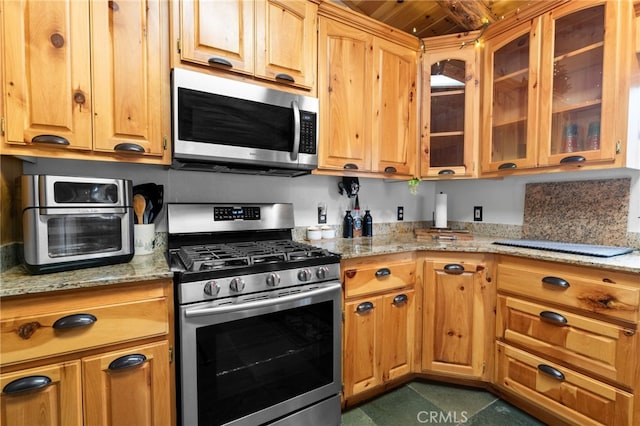 kitchen with appliances with stainless steel finishes and light stone counters