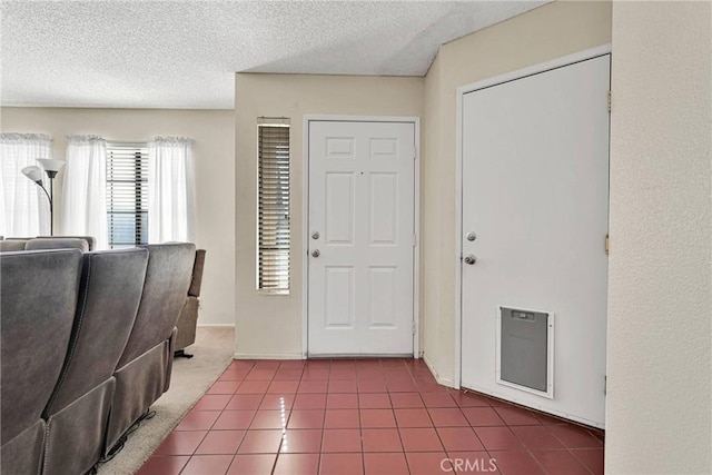 foyer entrance with tile patterned flooring and a textured ceiling