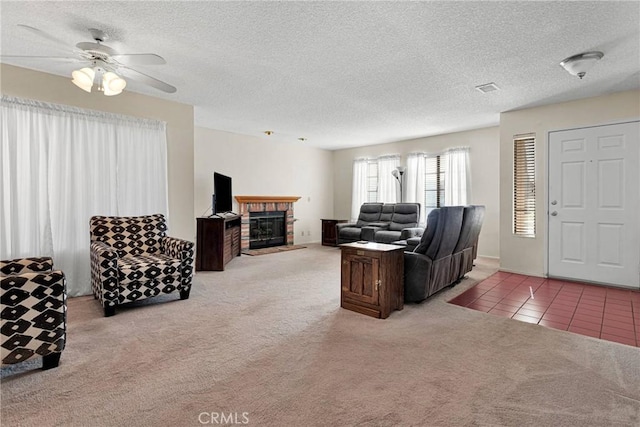 carpeted living room with ceiling fan, a fireplace, and a textured ceiling