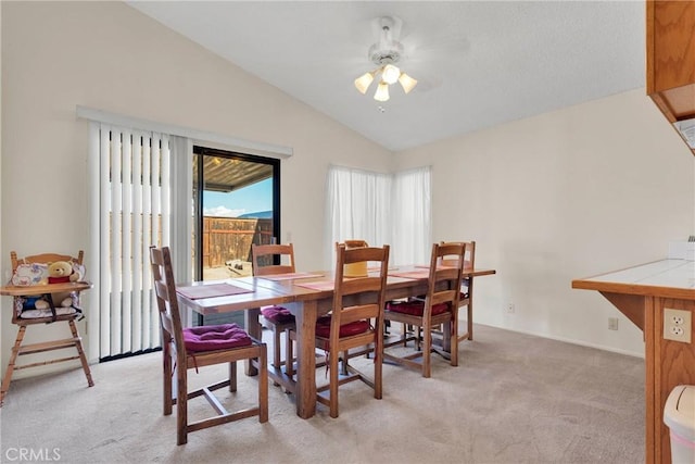 carpeted dining space featuring vaulted ceiling and ceiling fan