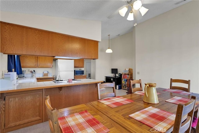 dining room with ceiling fan and high vaulted ceiling