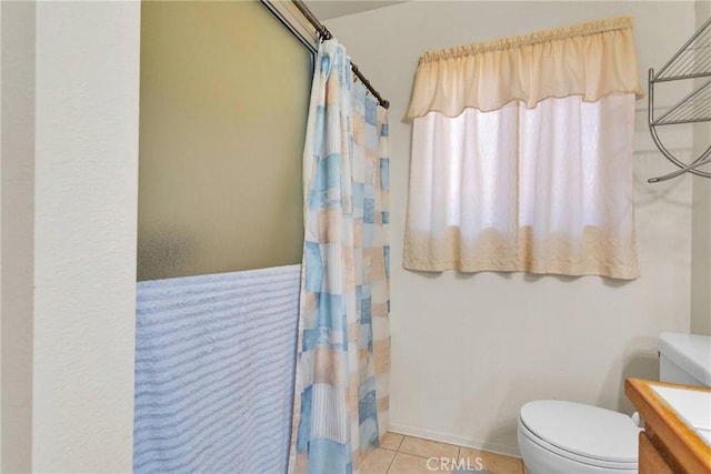 bathroom with tile patterned flooring, vanity, toilet, and walk in shower