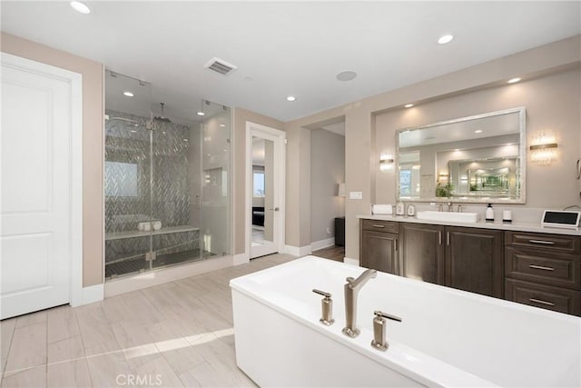 bathroom with vanity and separate shower and tub