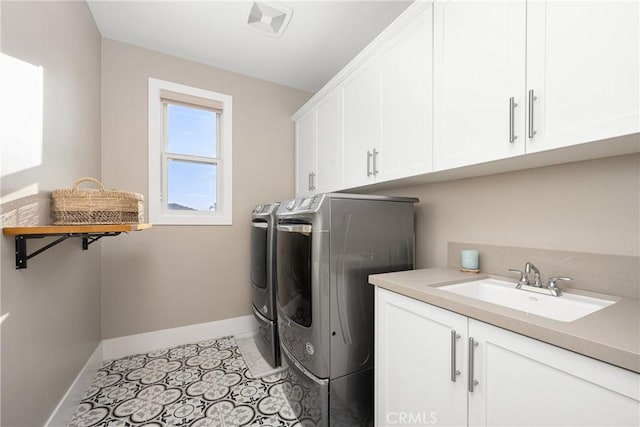 laundry area with cabinets, separate washer and dryer, sink, and light tile patterned floors