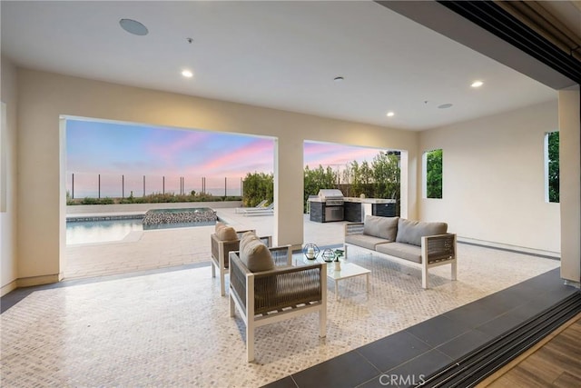 20436 W Liverpool Way, Porter Ranch, CA 91326 - patio terrace at dusk featuring exterior kitchen, outdoor lounge area, and grilling area