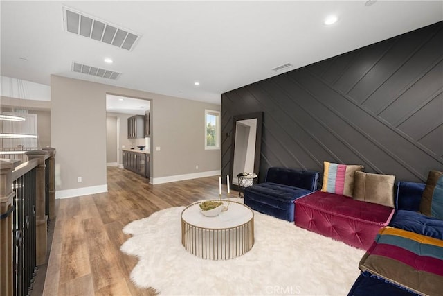 living room featuring wooden walls and light hardwood / wood-style floors