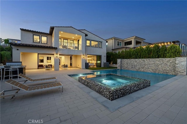 exterior space with an in ground hot tub and a patio