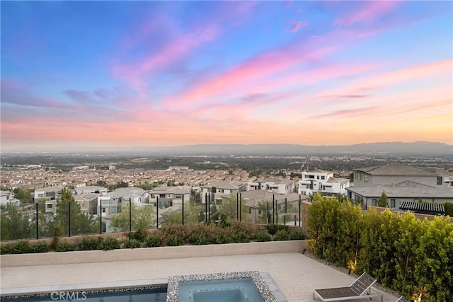 pool at dusk featuring a mountain view and a patio area