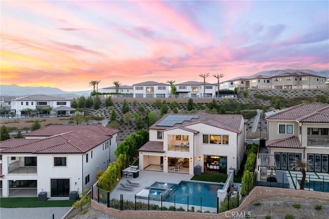 20436 W Liverpool Way, Porter Ranch, CA 91326 - back of property featuring a balcony, roof mounted solar panels, a residential view, a fenced backyard, and stucco siding