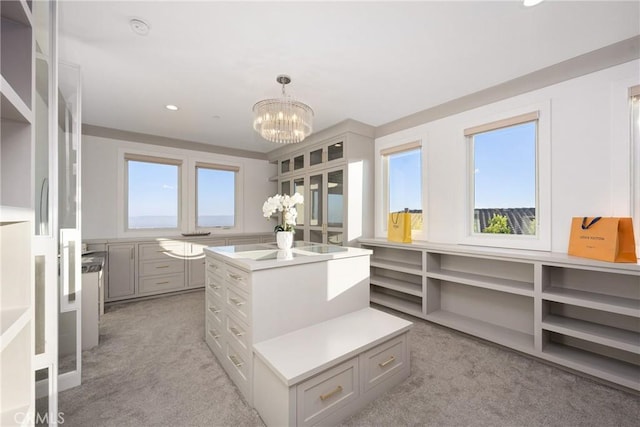 walk in closet featuring light carpet and a notable chandelier