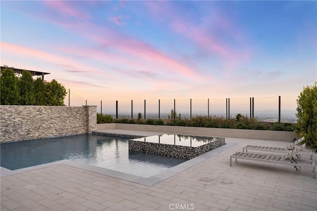 pool at dusk with a patio