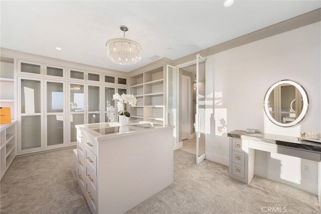 spacious closet featuring light carpet and a chandelier