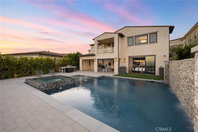 20436 W Liverpool Way, Porter Ranch, CA 91326 - back of house with a balcony, a patio, a pool with connected hot tub, and stucco siding