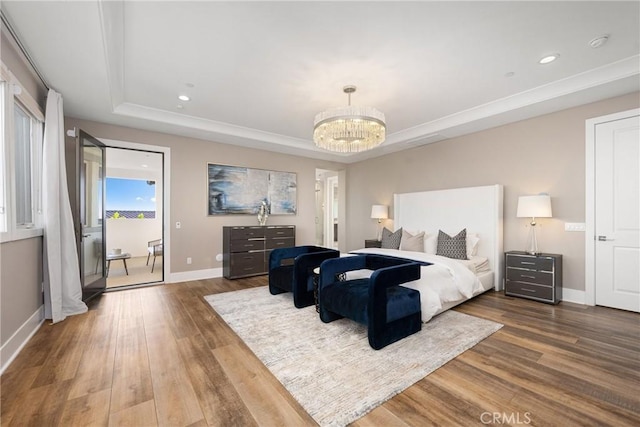 bedroom with a raised ceiling, hardwood / wood-style flooring, and a notable chandelier