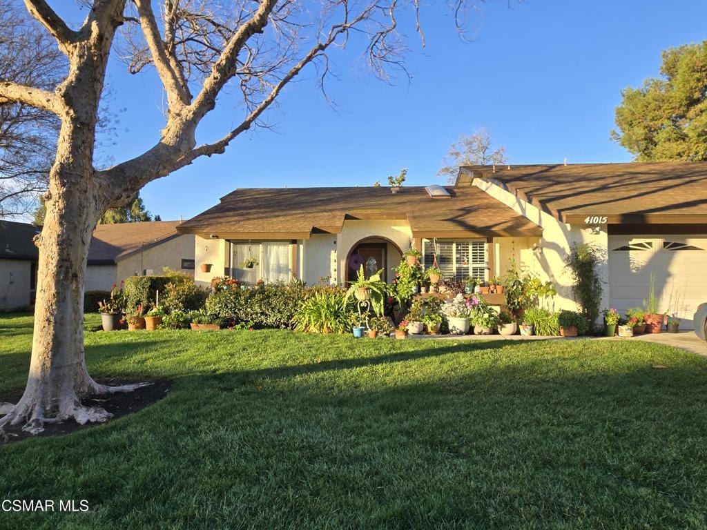 ranch-style house with a garage and a front yard