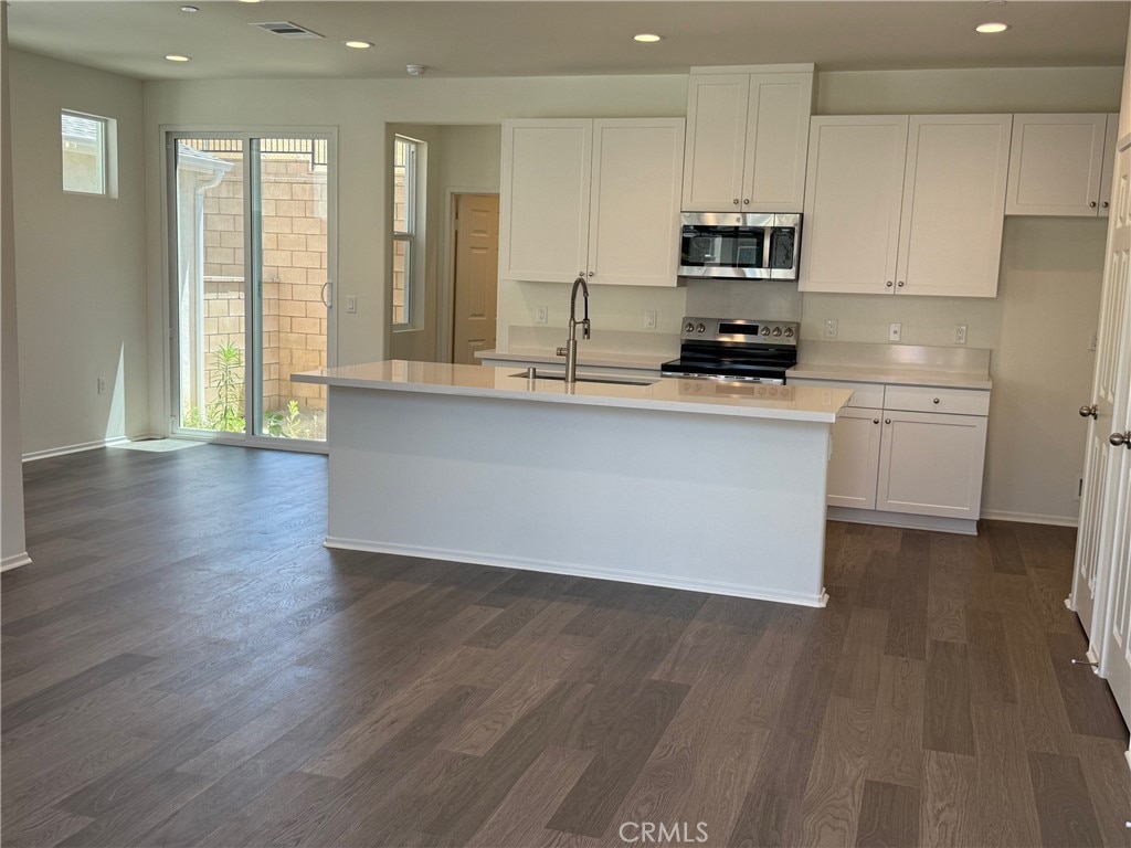 2255 Spring Meadow Ct, San Bernardino, CA 92346 - kitchen with appliances with stainless steel finishes, white cabinets, dark wood finished floors, light countertops, and recessed lighting