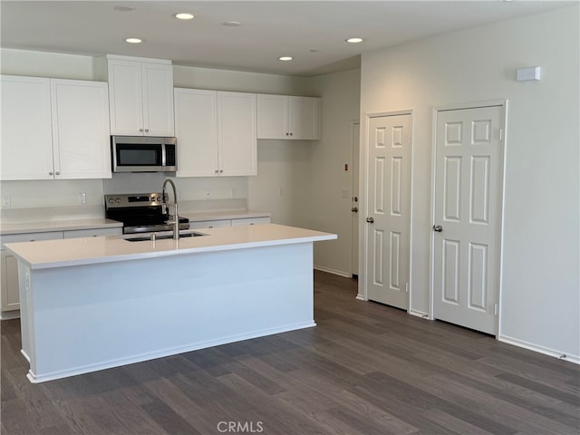 2255 Spring Meadow Ct, San Bernardino, CA 92346 - kitchen with appliances with stainless steel finishes, dark wood finished floors, white cabinetry, recessed lighting, and a center island with sink