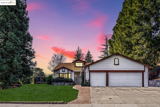 view of front of property with a garage and a yard