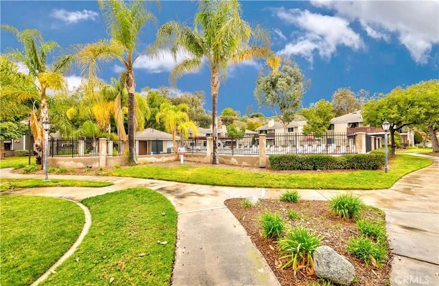 view of home's community featuring a residential view, a lawn, and fence