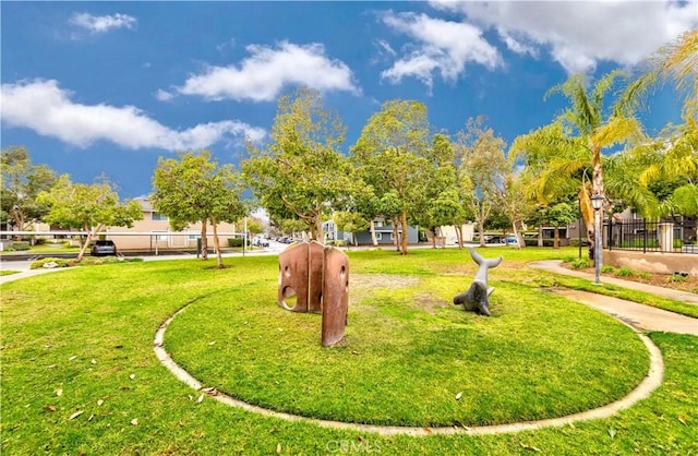 view of home's community featuring a lawn and fence