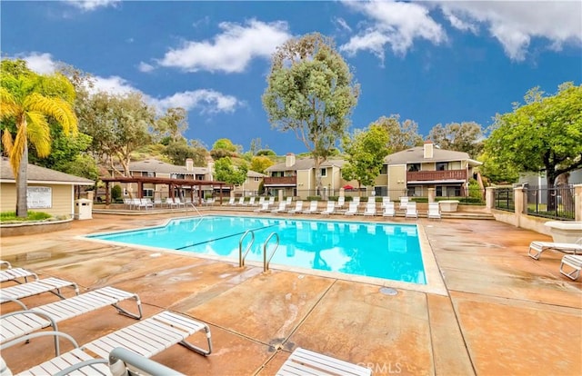 pool featuring a patio area, a residential view, and fence