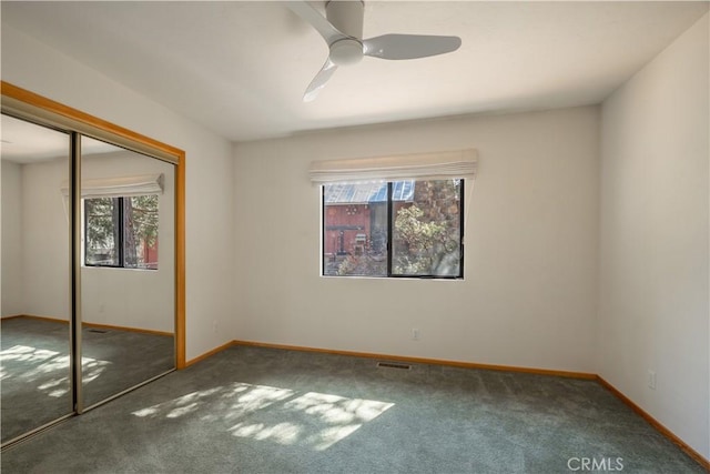 unfurnished bedroom with carpet flooring, visible vents, a ceiling fan, baseboards, and a closet