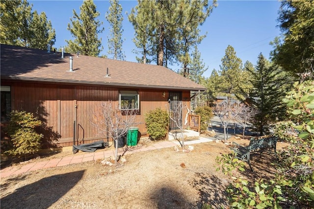 back of house with a shingled roof