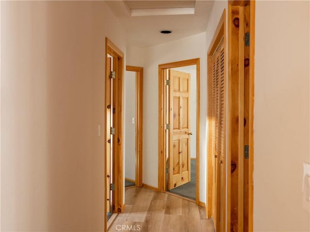 hall with light wood finished floors and baseboards