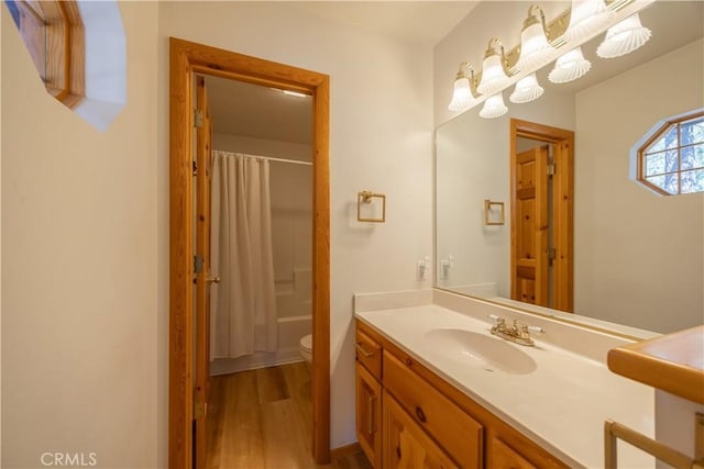 full bathroom with toilet, shower / bath combination with curtain, wood finished floors, and vanity