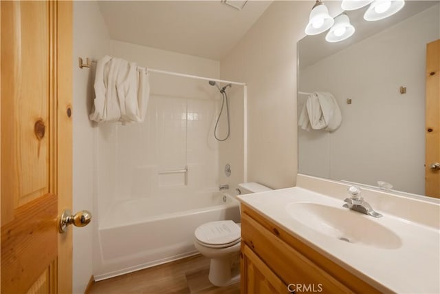 bathroom featuring bathtub / shower combination, vanity, toilet, and wood finished floors