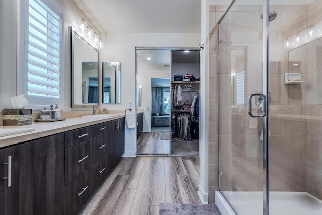 bathroom featuring hardwood / wood-style flooring, vanity, and a shower with shower door