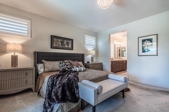 bedroom with connected bathroom and light carpet