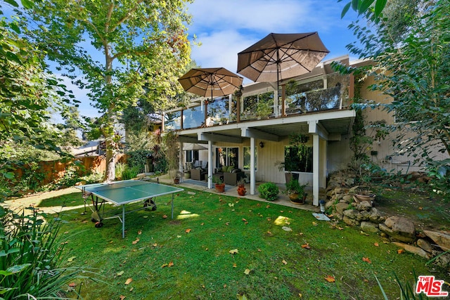 rear view of house featuring a patio area and a lawn