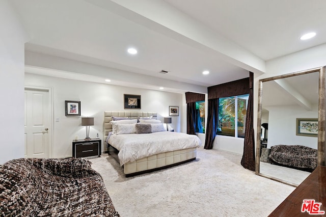 carpeted bedroom featuring beamed ceiling