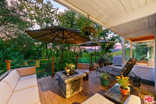 deck with an outdoor living space with a fire pit