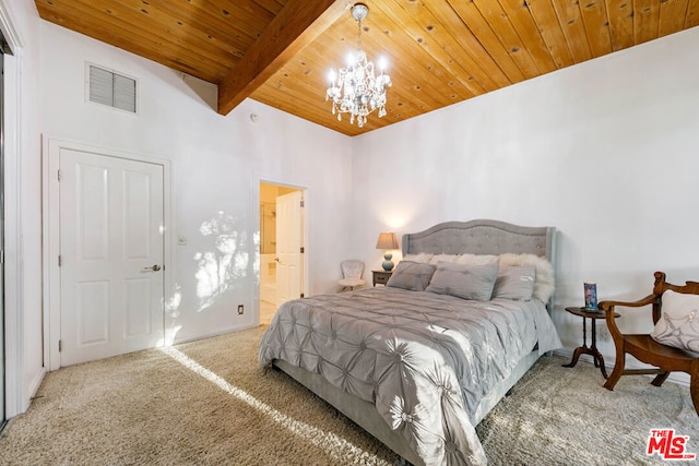 bedroom with connected bathroom, beamed ceiling, carpet floors, wood ceiling, and an inviting chandelier