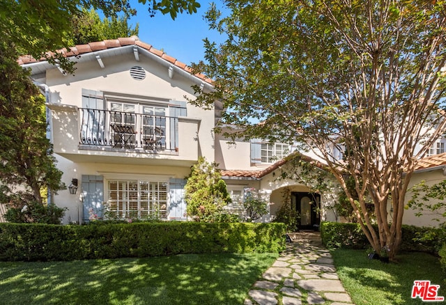 mediterranean / spanish-style home with a balcony and a front yard