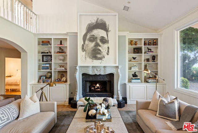 living room featuring dark wood-type flooring, a high end fireplace, and high vaulted ceiling