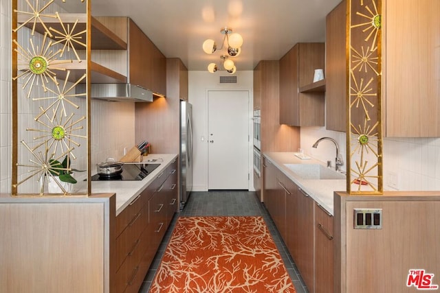 kitchen with dark tile patterned floors, appliances with stainless steel finishes, sink, and decorative backsplash